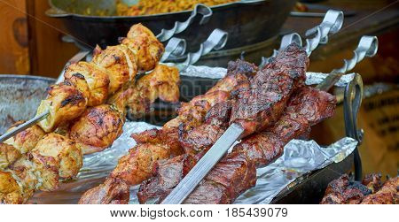 Closeup of some meat skewers being grilled in a barbecue