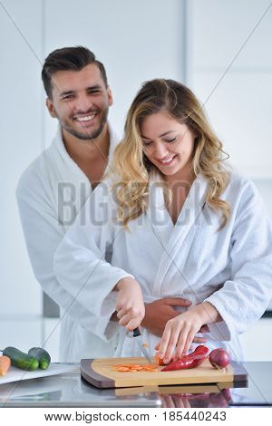 Happy couple cooking breakfast together in the kitchen.