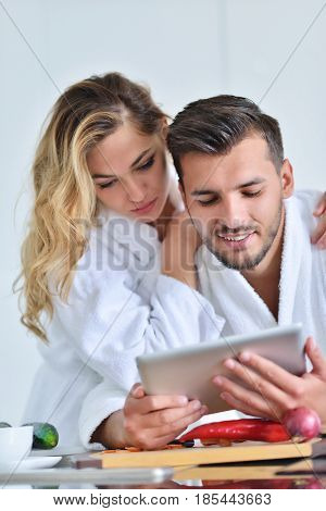 Happy couple cooking breakfast together in the kitchen.