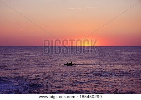 Beautiful sinrise on the sea with silhouette of the fishing boat