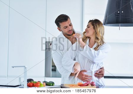 Happy couple cooking breakfast together in the kitchen.