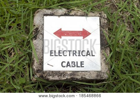 marking electrical way on the ground with green grass.