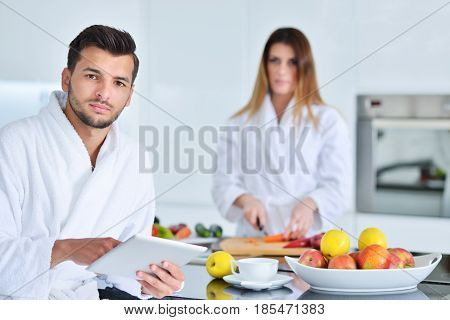 Happy couple cooking breakfast together in the kitchen.