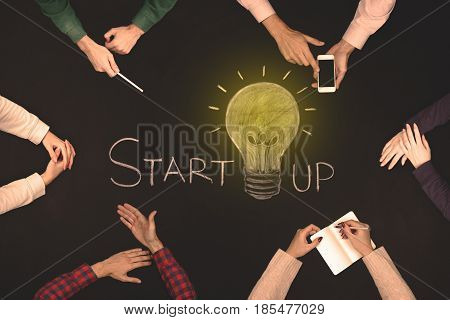 Teamwork startup concept - top view of six people. Blackboard table.