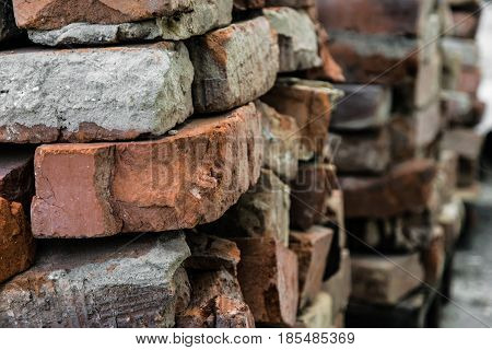 Old broken brick with cement residues on a blurred background