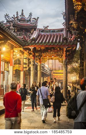 Taipei Taiwan - 6 October 2012: People praying and lighting incense at Longshan Temple in the center of the city