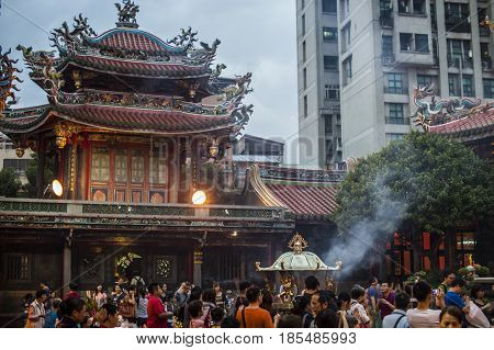 Taipei Taiwan - 6 October 2012: People praying and lighting incense at Longshan Temple in the center of the city