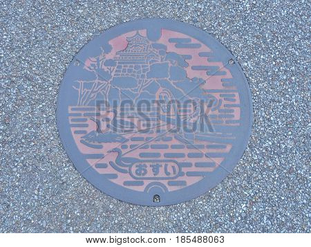 Aichi, Japan - February 18, 2017:A manhole cover of Inuyama, Aichi Prefecture, Japan. Ukai and Inuyama castle engraved on a manhole cover. Ukai is a traditional method of catching fish by cormorant.