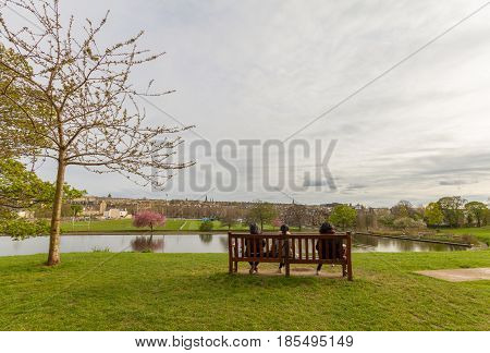 People Sitting On Bench Watching  Inverleith Park Pond, Edinburgh, Scotland