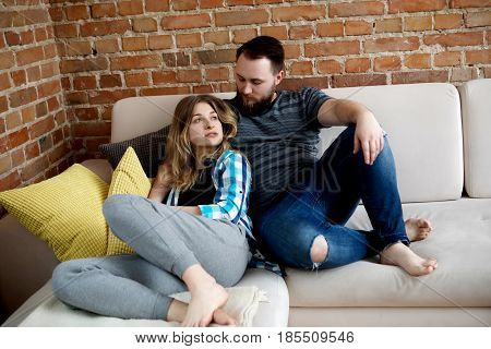 Young couple sitting on sofa nad embrancing, love time.
