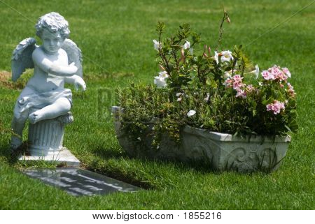 Estátua angelical, com vista para uma sepultura