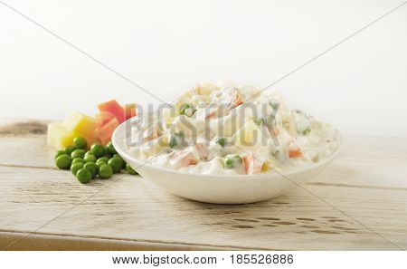 Russian salad Greek traditional spread appetizer on wooden surface