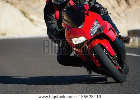 Man riding motorcycle in asphalt road curve with rural,motorcycle practice leaning into a fast corner on track