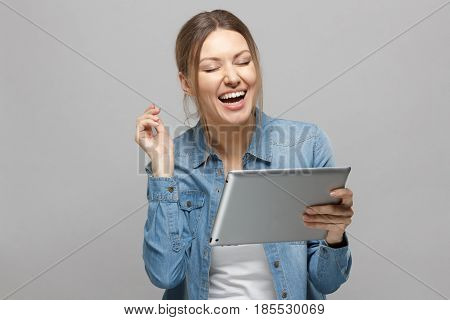Portrait Of Attractive European Female, Holding Tablet, Laughing With Opening Mouth, While Posing Ag