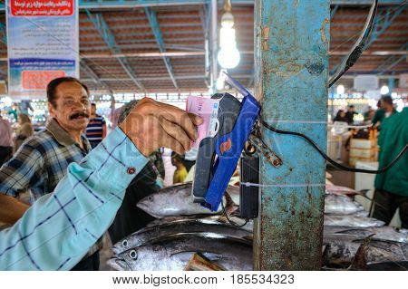 Bandar Abbas Hormozgan Province Iran - 16 april 2017: Payment for purchases on the fish market using a mobile terminal for credit cards.