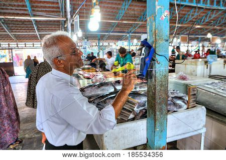 Bandar Abbas Hormozgan Province Iran - 16 april 2017: The Iranian man uses a mobile terminal to pay for purchases in the fish market.