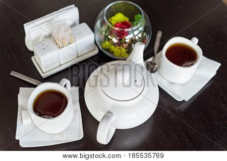 Teapot and cups are prepared for tea drinking in cafe