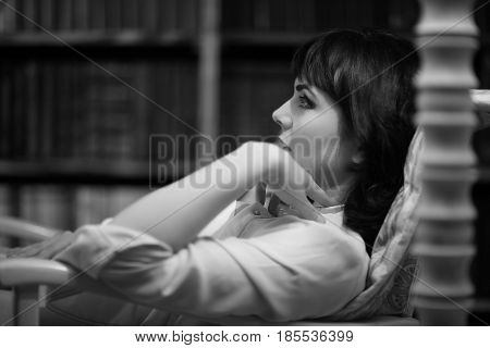 Sexy Brunette Resting In Chair At Home. Black And White Portrait Shot. Looking To The Left.