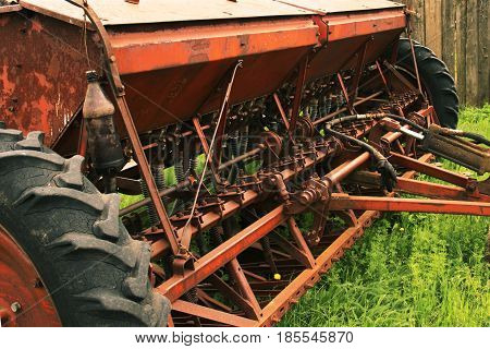 Old Grunge Seeding Machines Standing On The Grass. Decline In Agriculture