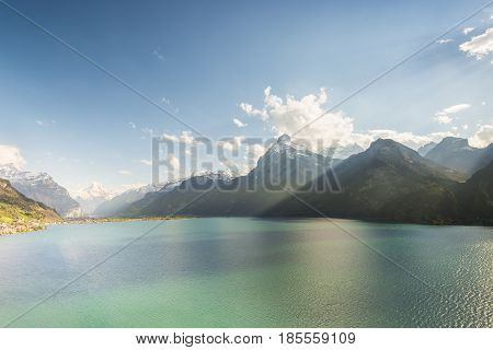 Gorgeous scenery of mountain landscape in contrasting light. The water of the lake in bright sunlight has a green turquoise color. Polarizing filter.