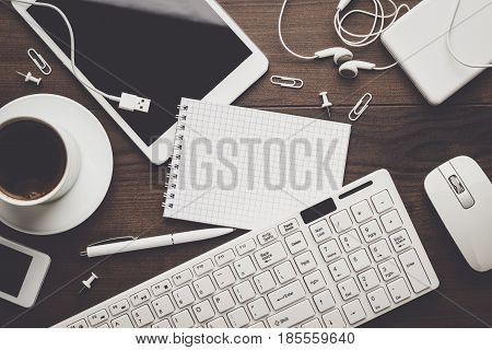 overhead of messy office table. working atmosphere on office table. wooden table with office supplies. office table concept with copy space.
