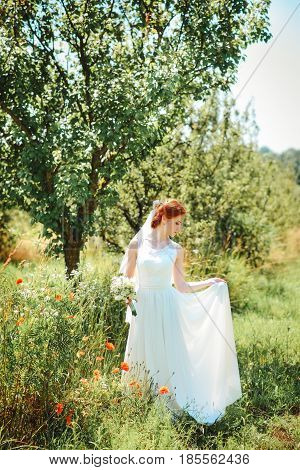 Young Beautiful Blonde Woman In Blooming Garden. Bride.