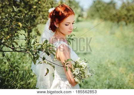 Young Beautiful Blonde Woman In Blooming Garden. Bride.