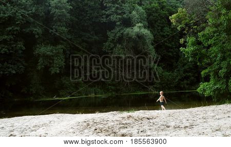 Boy on the background of the river in summer
