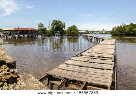 Wooden jetty bridge with seascape during sunny day at Kuala Penyu,Sabah,Borneo.