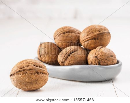 View on inshell walnut on white wooden background with copy space.