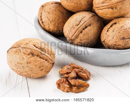 Close up view on inshell walnut on white wooden background