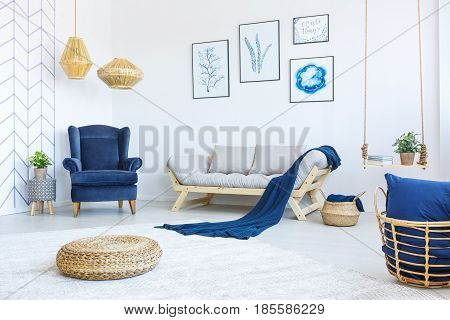 New white living room with blue armchair sofa rattan pouf