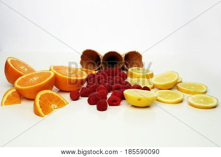 Cones And Colorful Various Fruits Raspberry ,lemon ,orange Slice Setup On White Background . Summer