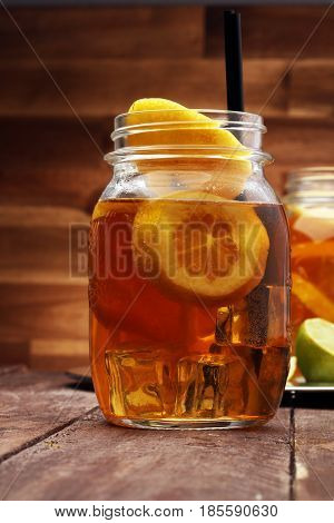 Iced Tea With Lemon Slices And Mint On Rustic Background