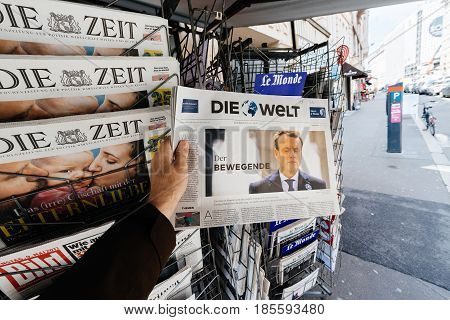 PARIS FRANCE - MAY 9 2017: Pov buying Die Welt newspaper front page with the picture of the newly elected French president Emmanuel Macron after the second round French Presidential election
