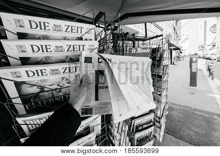 PARIS FRANCE - MAY 9 2017: Pov buying Die Welt newspaper front page with the picture of the newly elected French president Emmanuel Macron after the second round French Presidential election