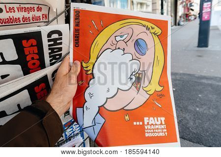 PARIS FRANCE - MAY 9 2017: Pov buying Charlie Hebdo newspaper front page with the picture of the newly Marine Le Pen