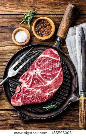 Meat. Raw beef marbled meat steak on vintage cast iron grill pan and spices on wooden rustic background. Top view