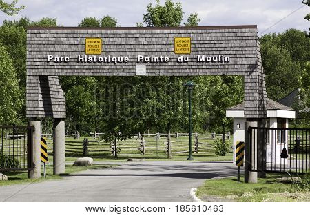 Notre Dame de Ile Perrot, Quebec - June 20, 2014 -- Close up of the entrance to Windmill Point Historic Site in Notre Dame de Ile Perrot, Quebec with trees and foliage in the background on a sunny day in June.