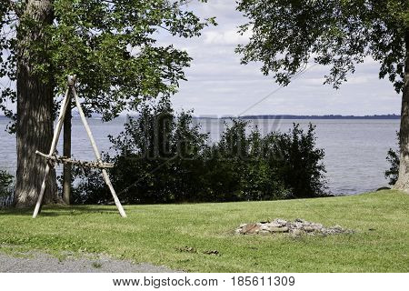 Vertical of a whimsical scarecrow in a dried out garden in Notre Dame de Ile Perrot, Quebec on a sunny day in June.