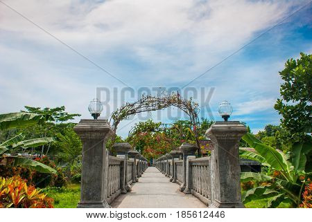 Architectural wonders at the Karangasem water temple in Bali, Indonesia. Very Beautiful stone bridge with flowers.