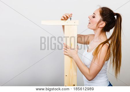 Woman Assembling Wooden Furniture. Diy.