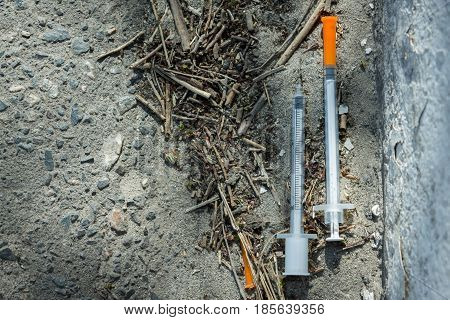 Used syringes on the ground. The danger of addiction and venereal diseases.