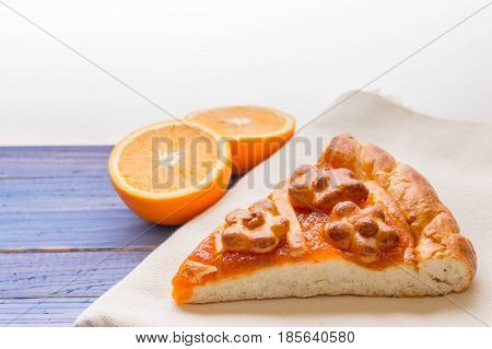 A piece of cake with orange confiture on a wooden table. Delicious dessert.
