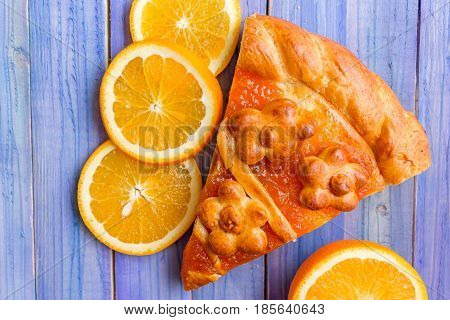 A piece of cake with orange confiture on a wooden table. Delicious dessert.