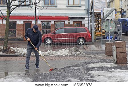 Oulu, Finland - April 11, 2017: man is cleaning up the market square in Oulu, Finland