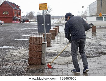 Oulu, Finland - April 11, 2017: man is cleaning up the market square in Oulu, Finland