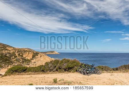 Six Bicycles Resting On Bush On Coastal Path In Corsica