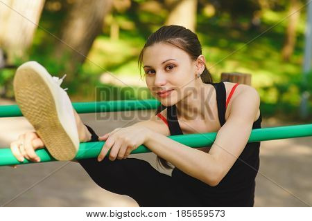 A girl in a park on a sports ground is engaged in gymnastics, training
