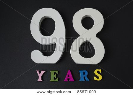 Letters And Numbers Ninety-eight Years Old On A Black Background.